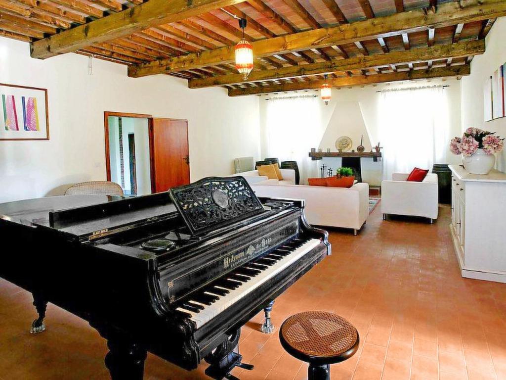 - un piano noir dans le salon avec canapé dans l'établissement Villa Beboli by Interhome, à Lamporecchio