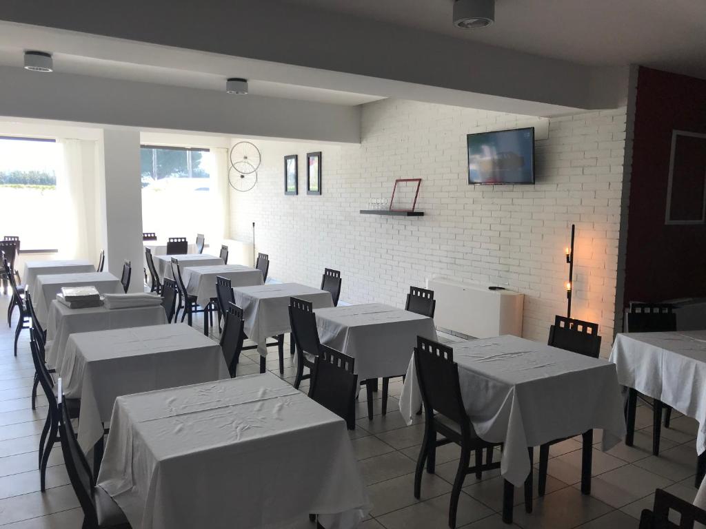 une salle à manger avec des tables et des chaises blanches dans l'établissement Hotel Royal, à San Benedetto del Tronto