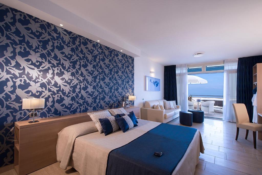 une chambre avec un lit et un salon dans l'établissement Hotel I Ginepri, à Marina di Castagneto Carducci