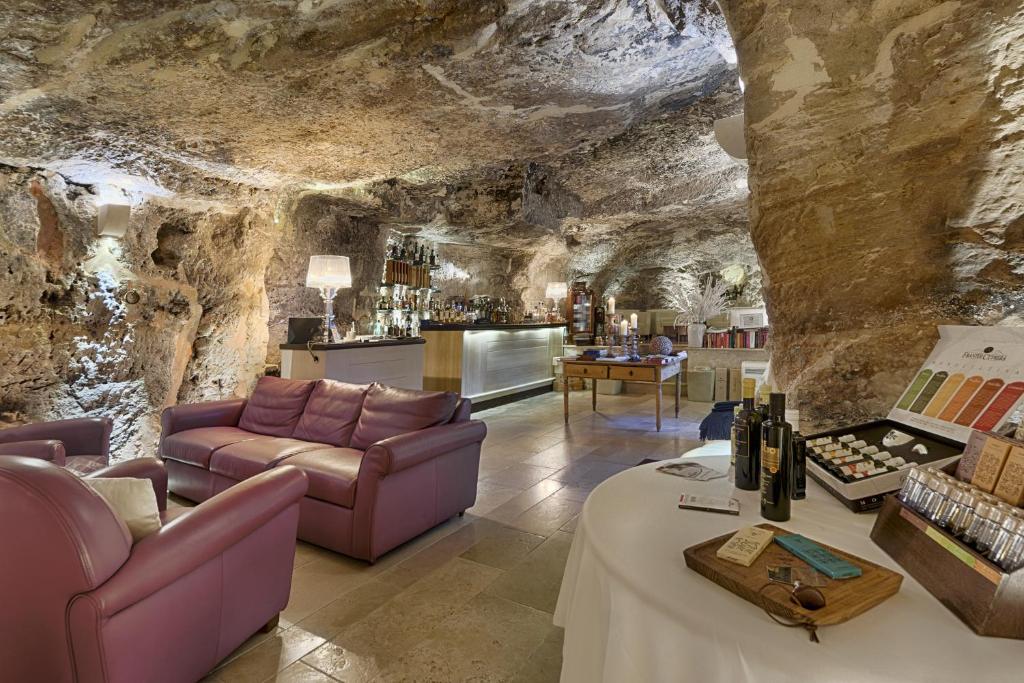 - un salon dans une grotte avec des meubles violets dans l'établissement Locanda Don Serafino Historical Boutique Hotel, à Raguse