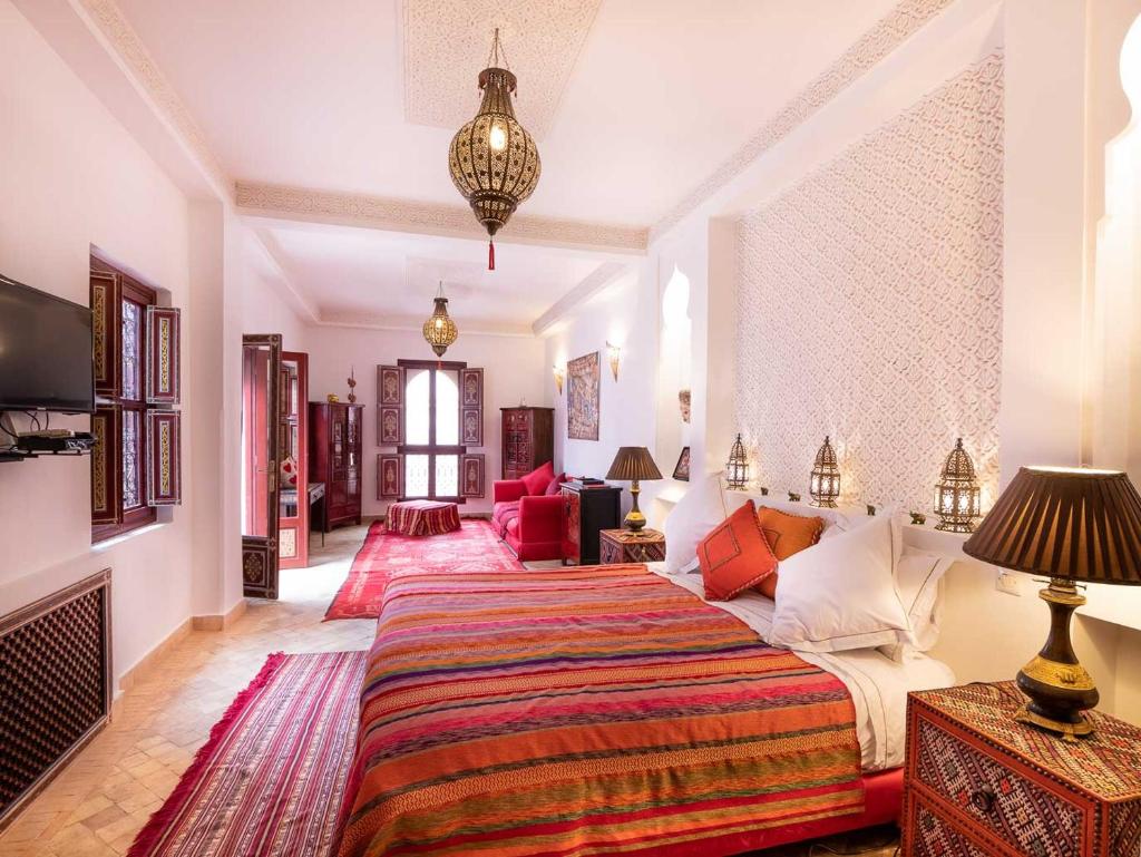 une chambre avec un lit et un salon dans l'établissement Riad Passali, à Marrakech