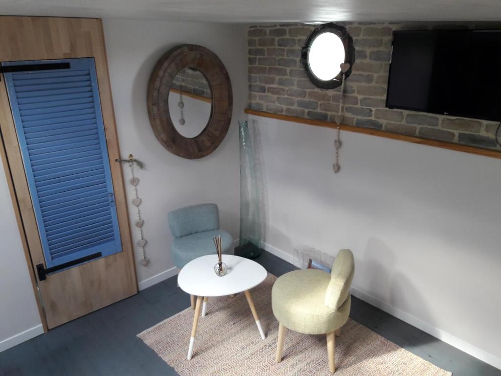 une pièce avec une table et deux chaises et une télévision dans l'établissement Péniche La Belle Aimée, à Aigues-Mortes