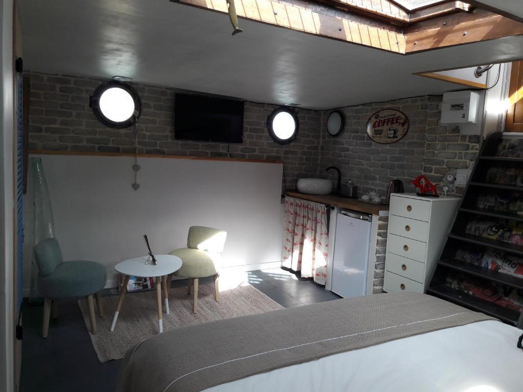 une chambre avec un lit et une table et une cuisine dans l'établissement Péniche La Belle Aimée, à Aigues-Mortes