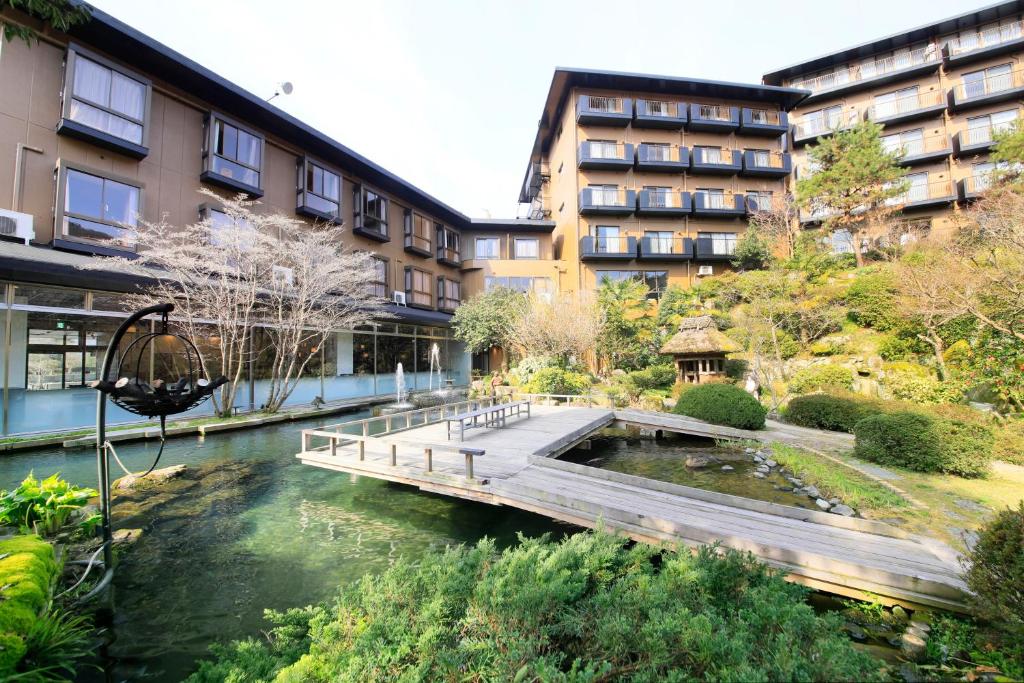 un pont sur une rivière devant un bâtiment dans l'établissement Hotel Kamogawaso, à Takekara