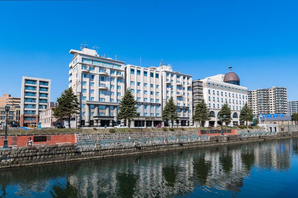 un groupe de bâtiments à côté d'une rivière dans l'établissement Hotel Sonia Otaru, à Otaru