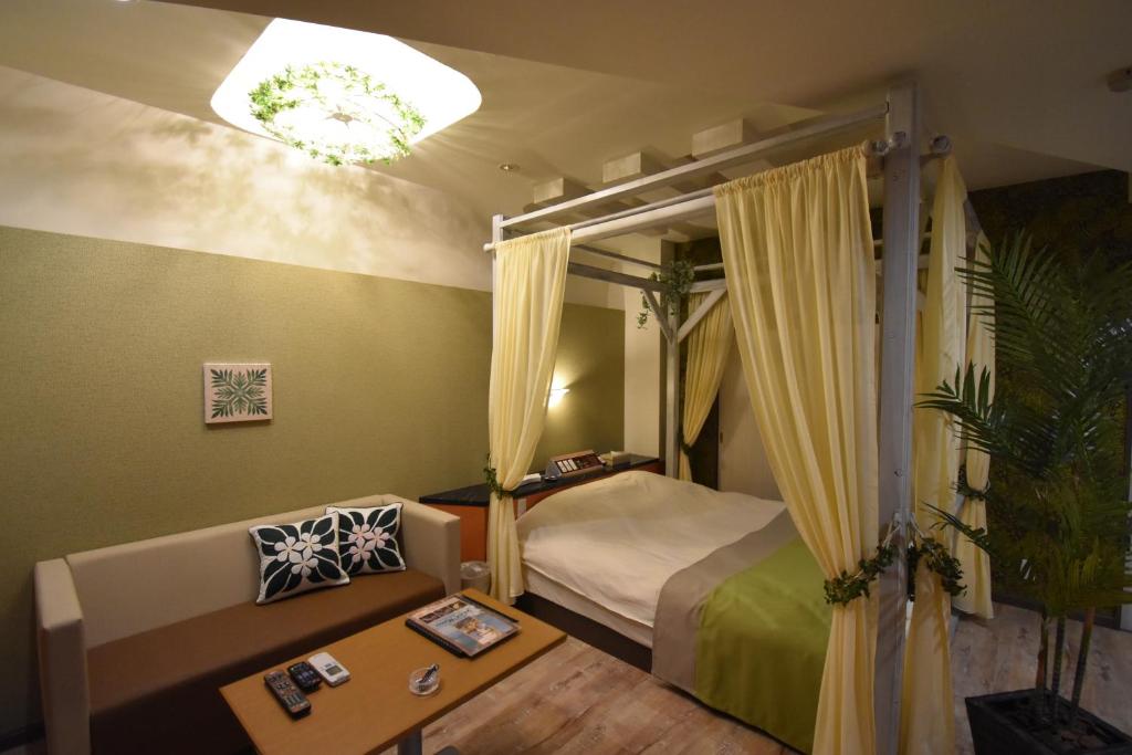 une chambre avec un lit, un canapé et une table dans l'établissement Hotel Melia RESORT(Adult Only), à Fuefuki