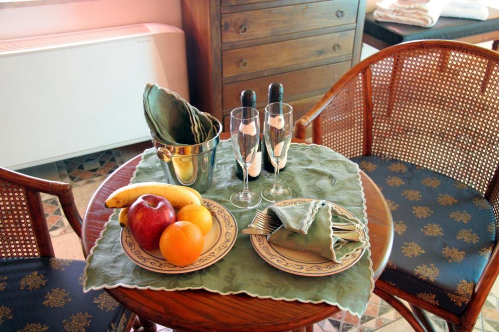 - une table avec une assiette de fruits et des verres à vin dans l'établissement Hotel U' Bais, à Scilla