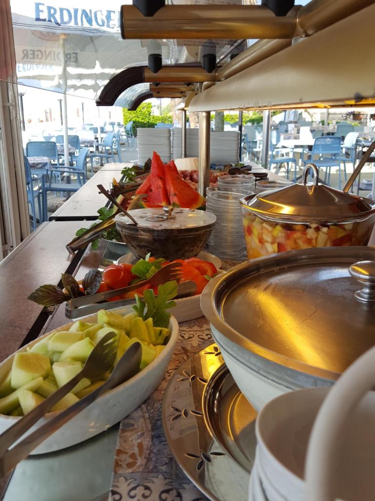 une table avec des bols et des assiettes de nourriture dans l'établissement Hotel Righetto Fronte Mare, à Cavallino-Treporti