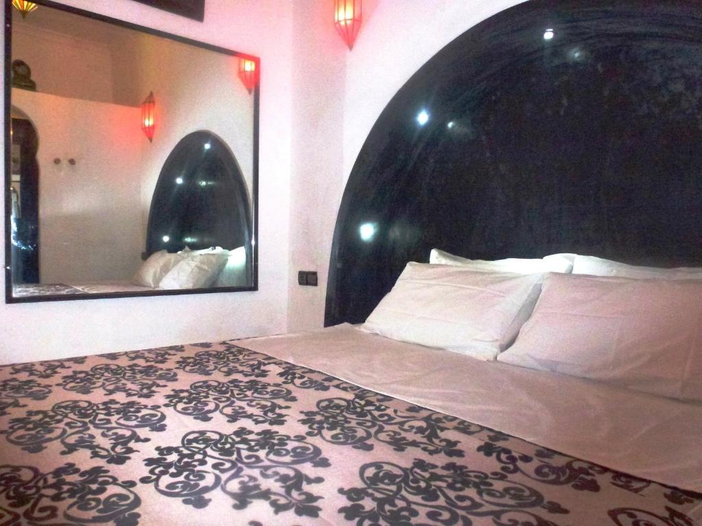 une chambre avec un grand lit et un miroir dans l'établissement Ryad Laârouss Family, à Marrakech 34 autres photos