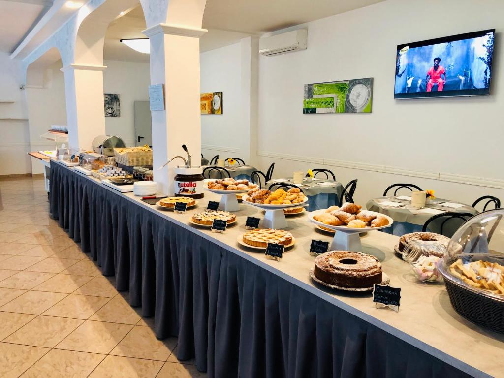 une longue table remplie de différents types de nourriture dans l'établissement Hotel Niagara Riccione, à Riccione