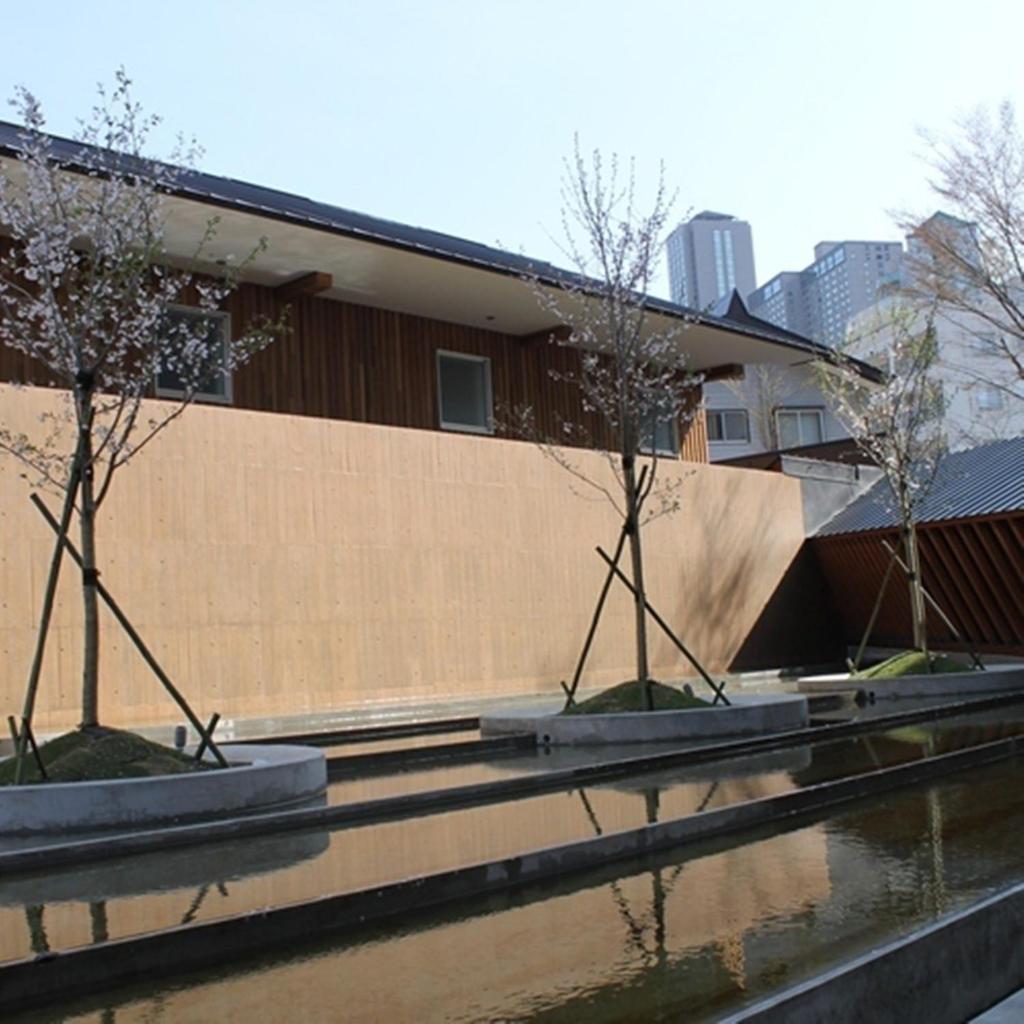Deux arbres en pots devant un bâtiment dans l'établissement Four Seasons Yuzawa Quattro, à Yuzawa