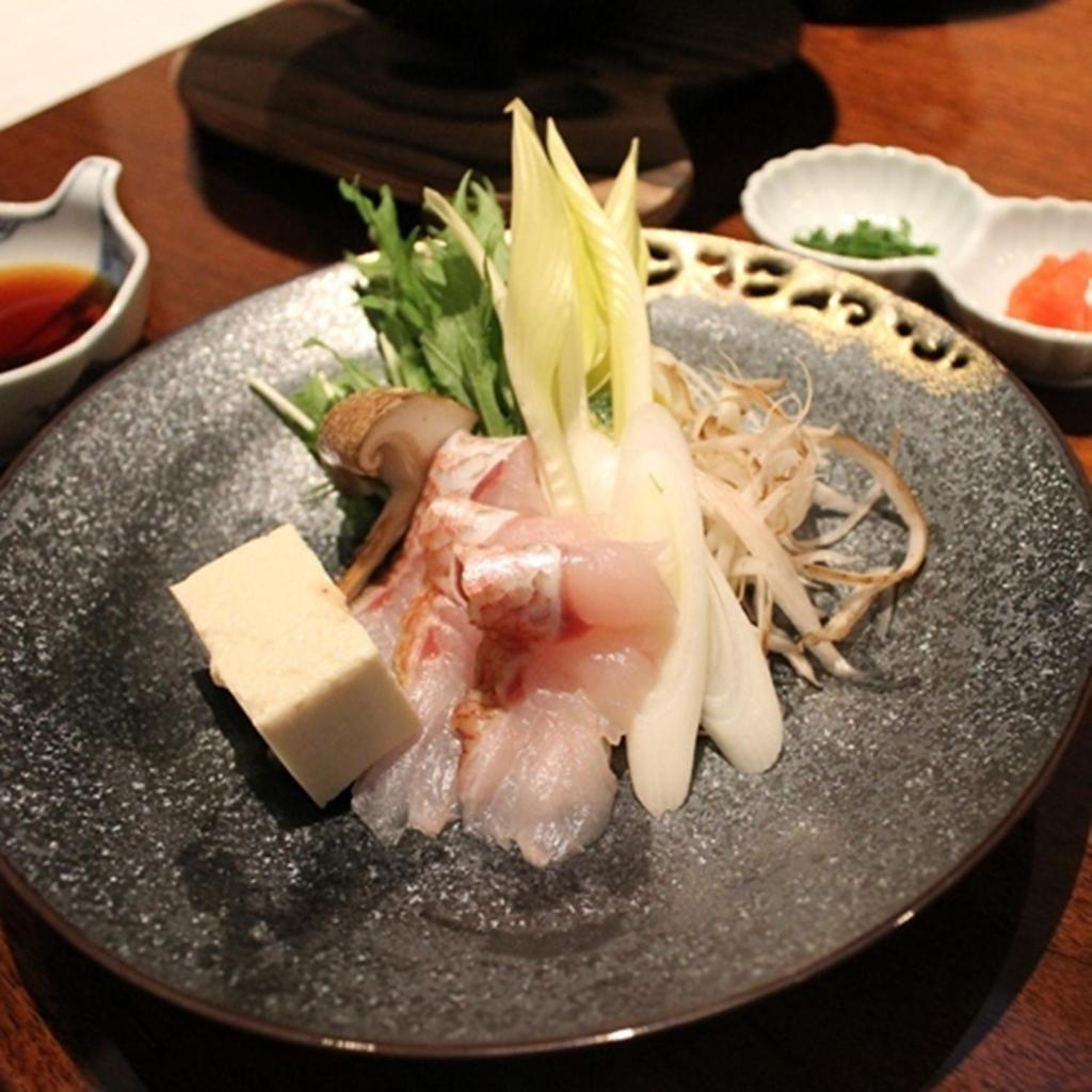 une assiette de nourriture avec de la viande et des nouilles sur une table dans l'établissement Four Seasons Yuzawa Quattro, à Yuzawa