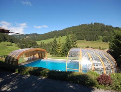 une serre et une piscine dans une cour dans l'établissement Hôtel Chalet Alpage, à La Clusaz
