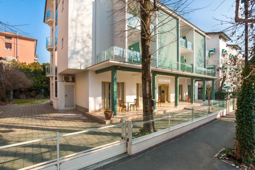 - un bâtiment avec une façade en verre et une terrasse dans l'établissement Hotel Zamagna, à Cesenatico