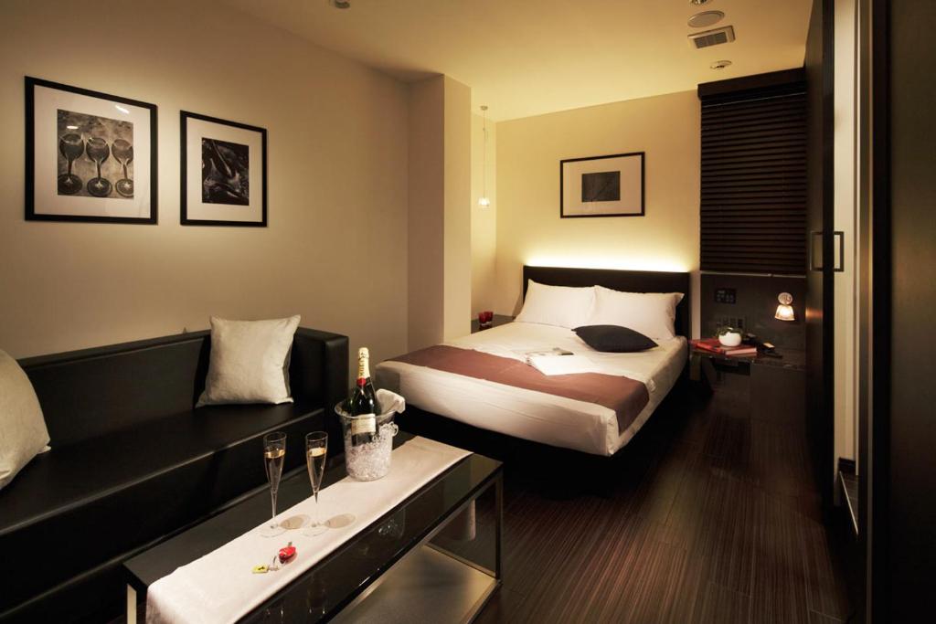 une chambre d'hôtel avec un lit et un canapé dans l'établissement Hotel UNO Nishikawaguchi Nishiguchi, à Kawaguchi