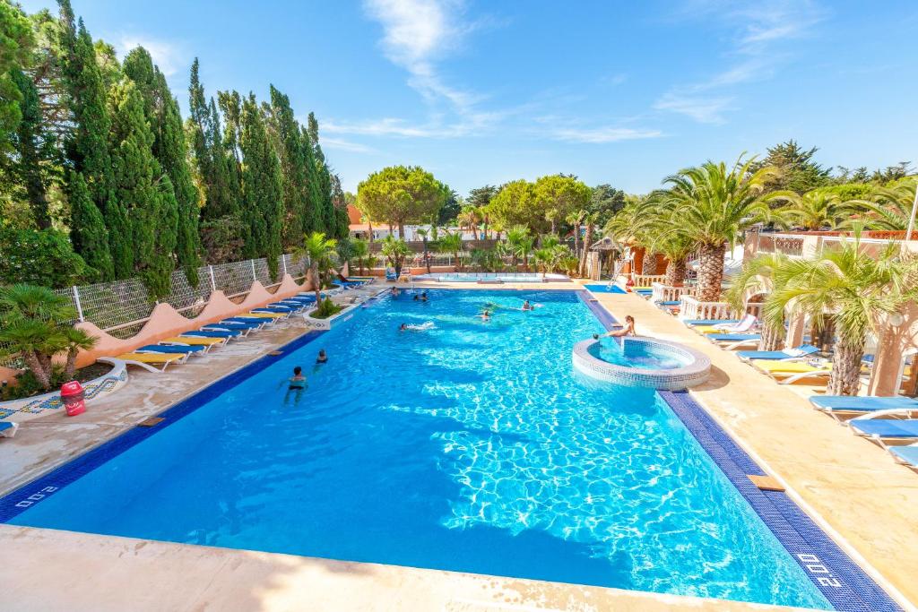 - une piscine dans un complexe avec des personnes dans l'établissement Camping La Croix du Sud, au Barcarès