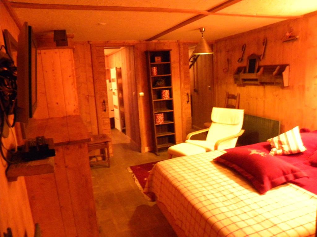 une chambre avec un lit et une chaise dans l'établissement CHALET GRINCH 90m2, 3 Sdb, skis aux pieds, wifi, à Tignes