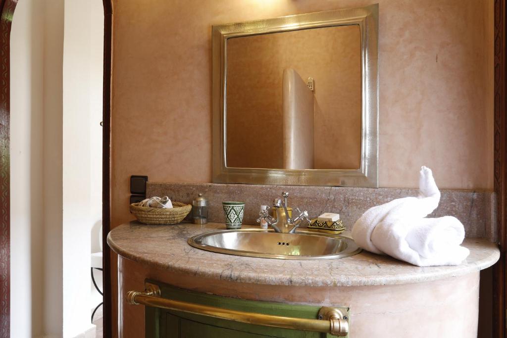 La salle de bains est pourvue d'un lavabo, d'un miroir et d'une serviette. dans l'établissement Riad Daria Suites & Spa, à Marrakech