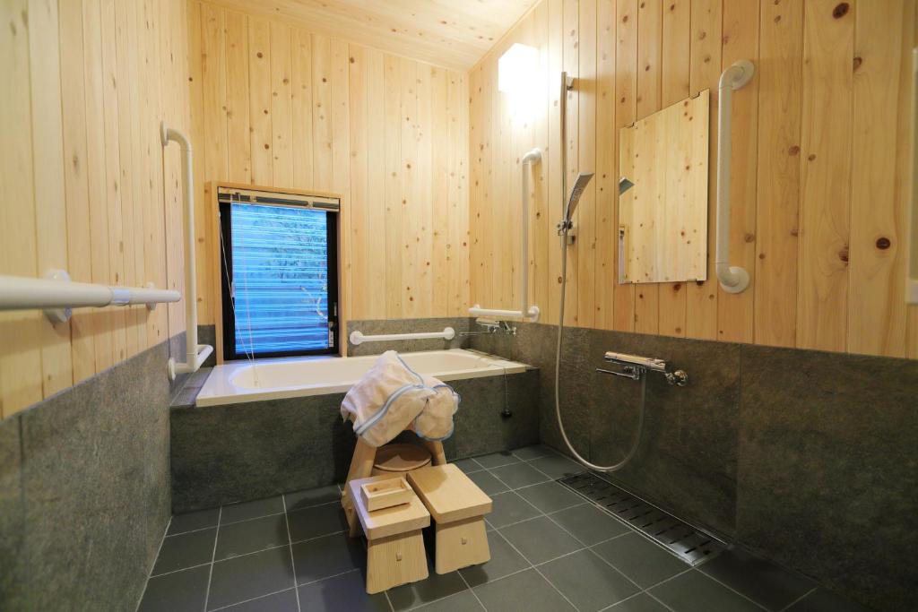 une salle de bain avec baignoire et douche dans l'établissement Ryokan Tanoya, à Kyoto