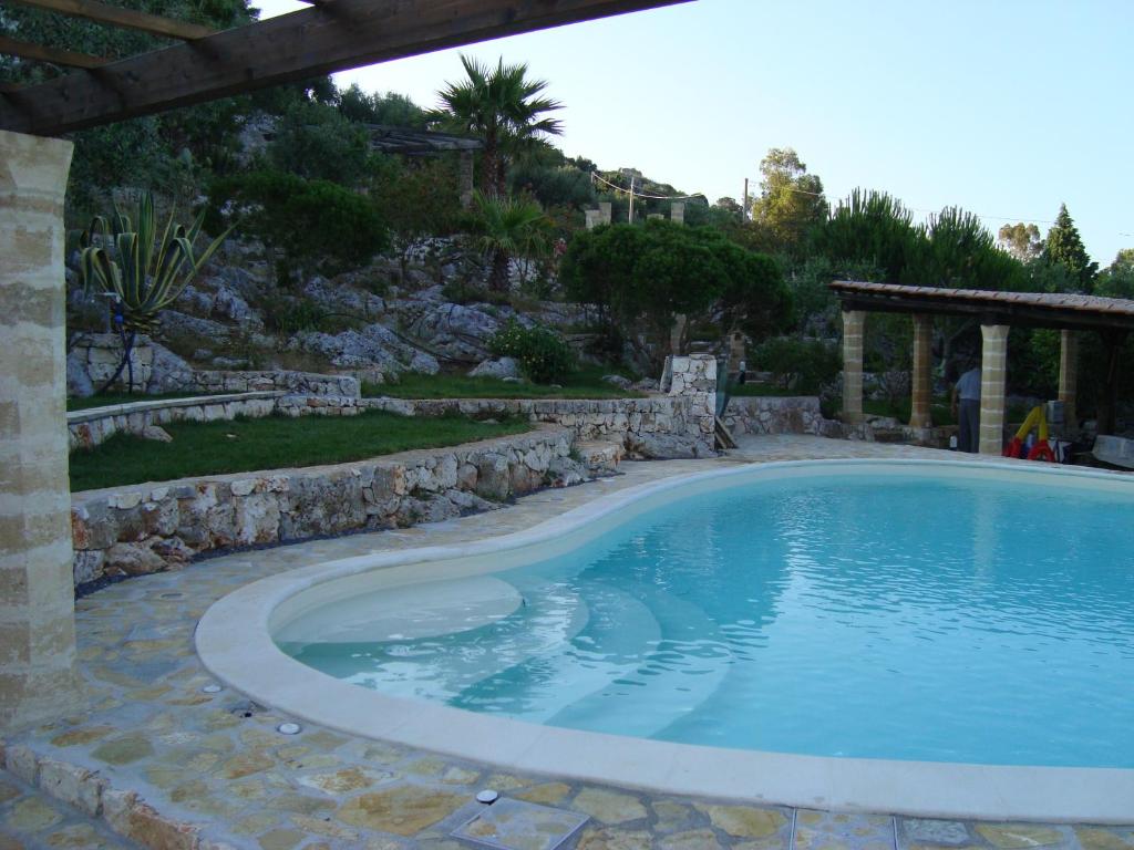 - une grande piscine dans une cour dotée d'un mur en pierre dans l'établissement Villa del Mito - Blue Marine, à Tricase