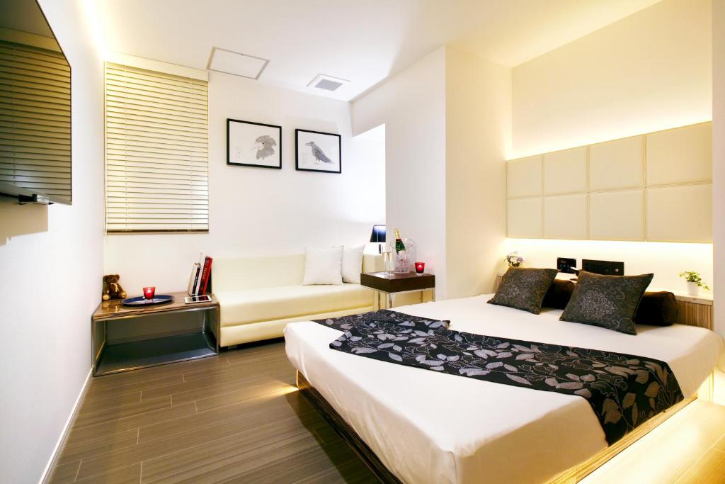 une chambre d'hôtel avec un lit et un canapé dans l'établissement Hotel DUO kinsicho, à Tokyo