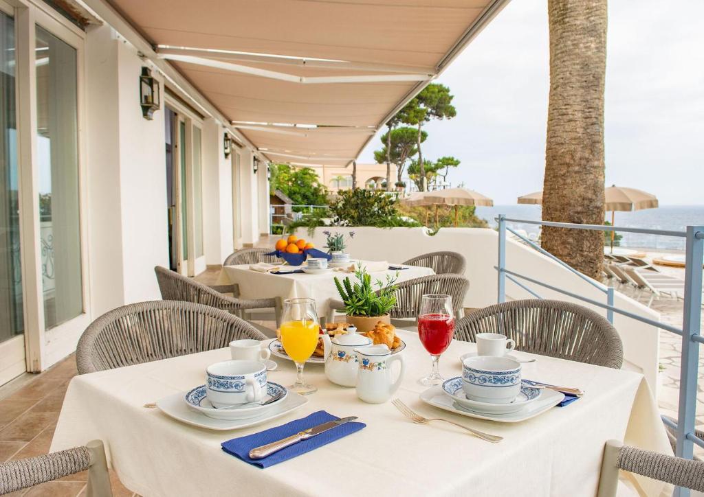- une table avec des verres de jus d'orange sur un balcon dans l'établissement Hotel Gran Paradiso, à Ischia