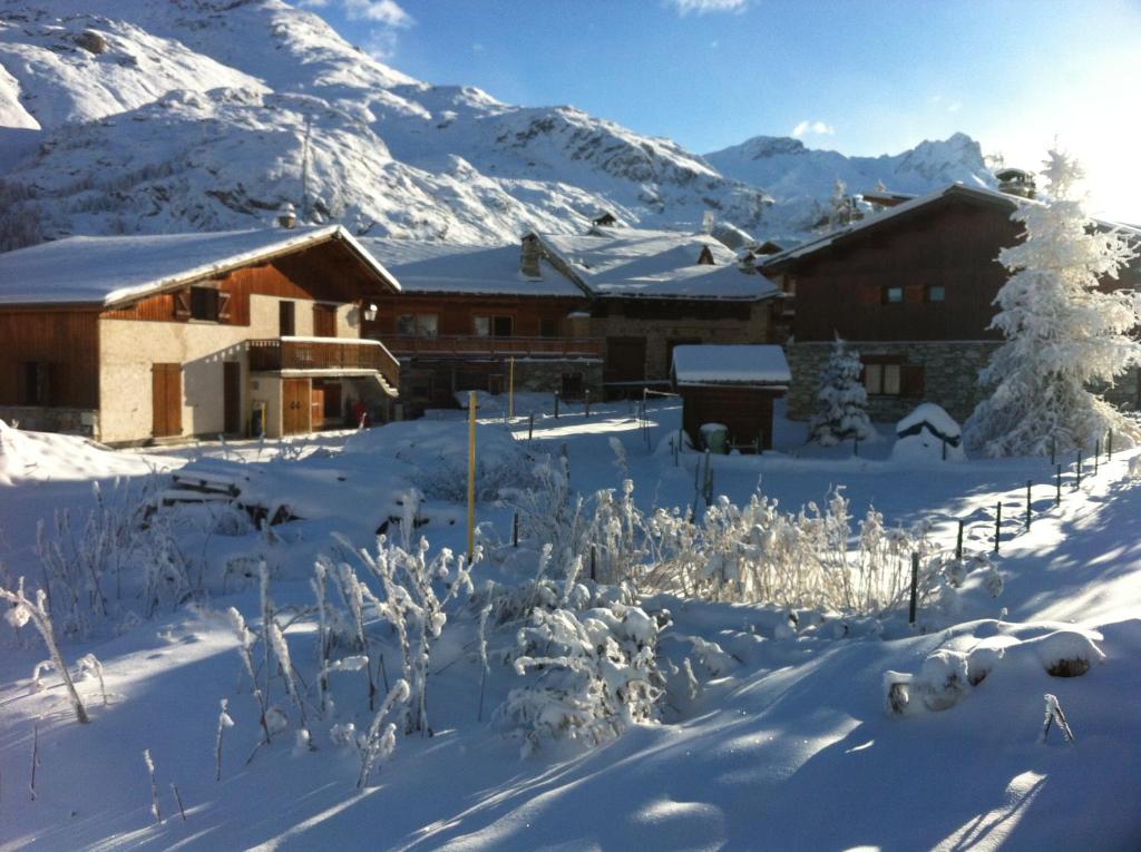 un lodge dans la neige avec des montagnes en arrière-plan dans l'établissement CHALET GRINCH 90m2, 3 Sdb, skis aux pieds, wifi, à Tignes