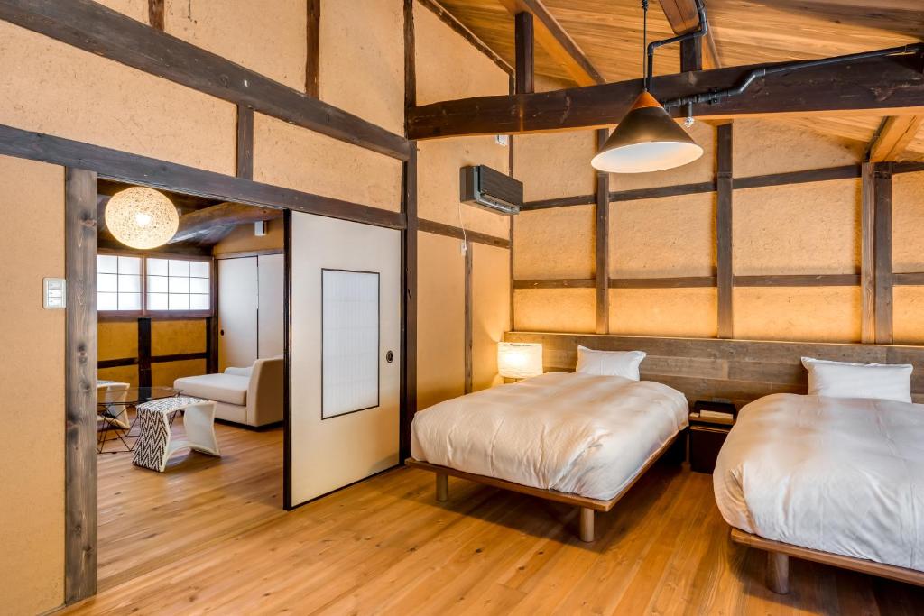 une chambre avec deux lits et un salon dans l'établissement EN Takeda Castle Town Hotel, à Asago