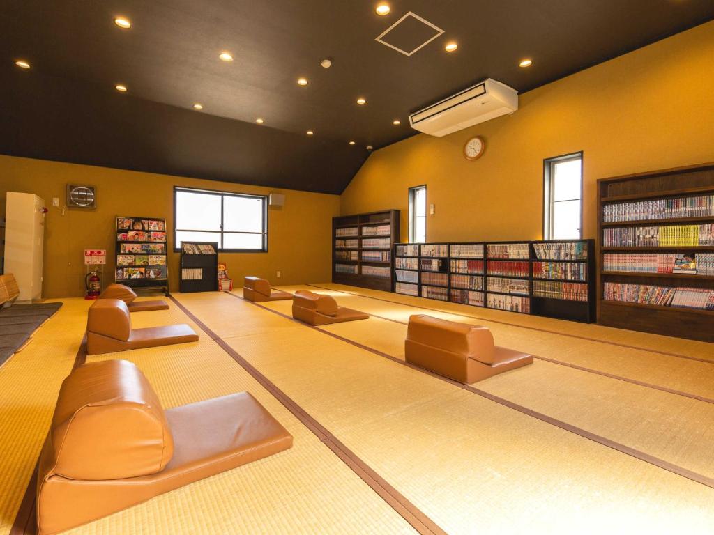 une piste de bowling avec des canapés et des chaises dans une bibliothèque dans l'établissement Katsuragi Onsen Happuu No Yu, à Katsuragi