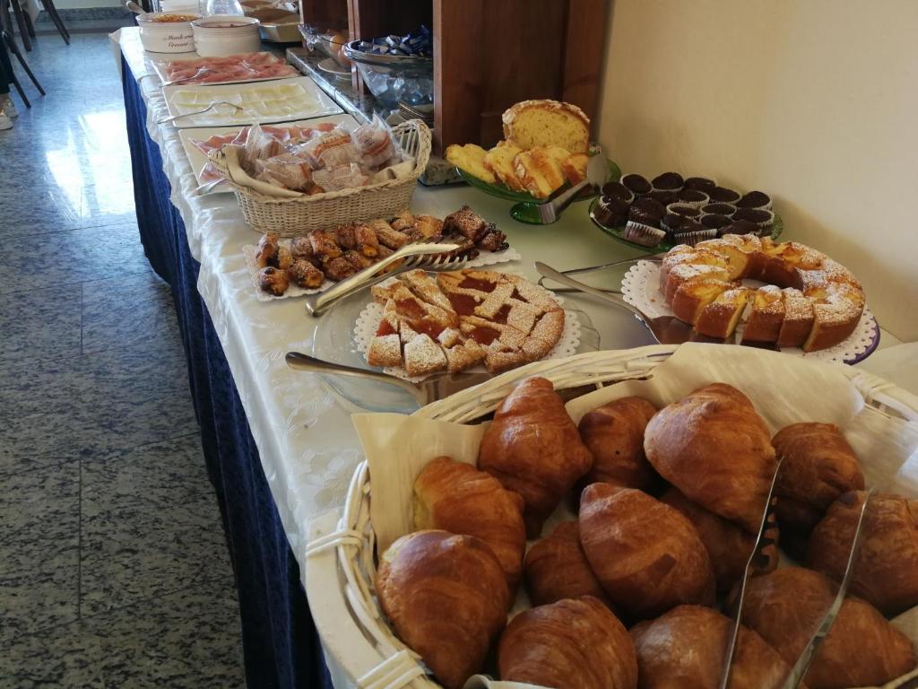 - un buffet de viennoiseries et de pains sur une table dans l'établissement Hotel Residence Villa Jolanda, à Lido di Camaiore