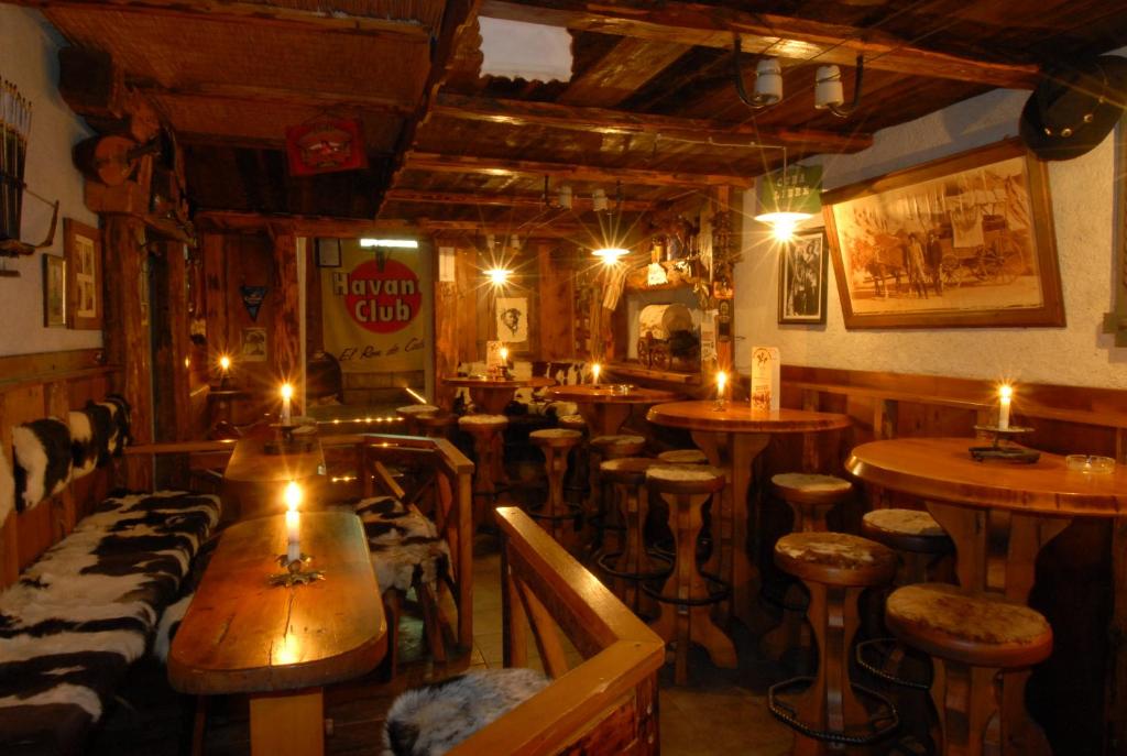 un bar avec des tables et des tabourets en bois et des bougies dans l'établissement Alpenlandhotel Rodeneggerhof, à Rodengo