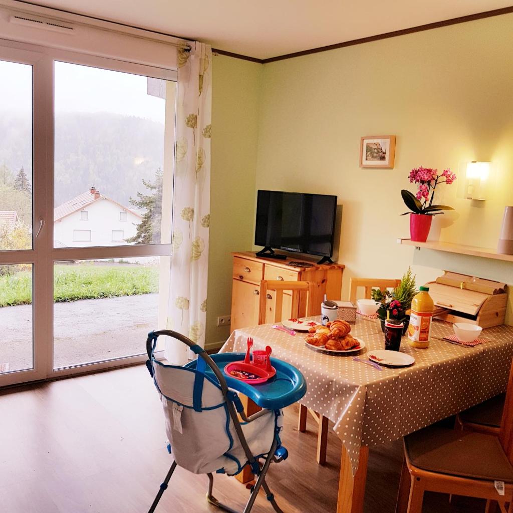 une salle à manger avec une table et une télévision dans l'établissement APPT 3* LE HAUT DES LACS, à Xonrupt-Longemer