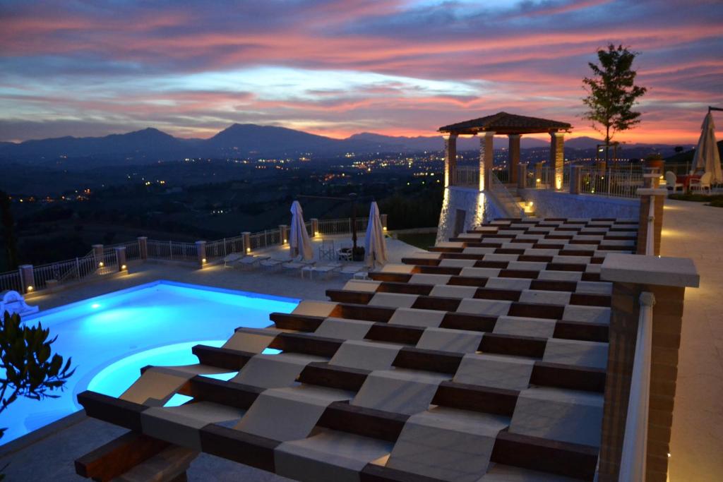 une piscine au sommet d'un immeuble avec un coucher de soleil dans l'établissement Incantea Resort, à Tortoreto Lido
