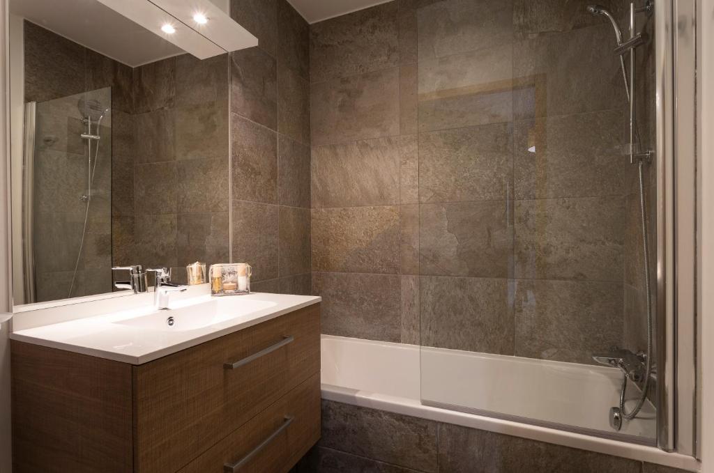 une salle de bain avec un lavabo, une douche et une baignoire dans l'établissement TERRESENS - Le Diamant des Neiges, à Plagne 1800 27 autres photos