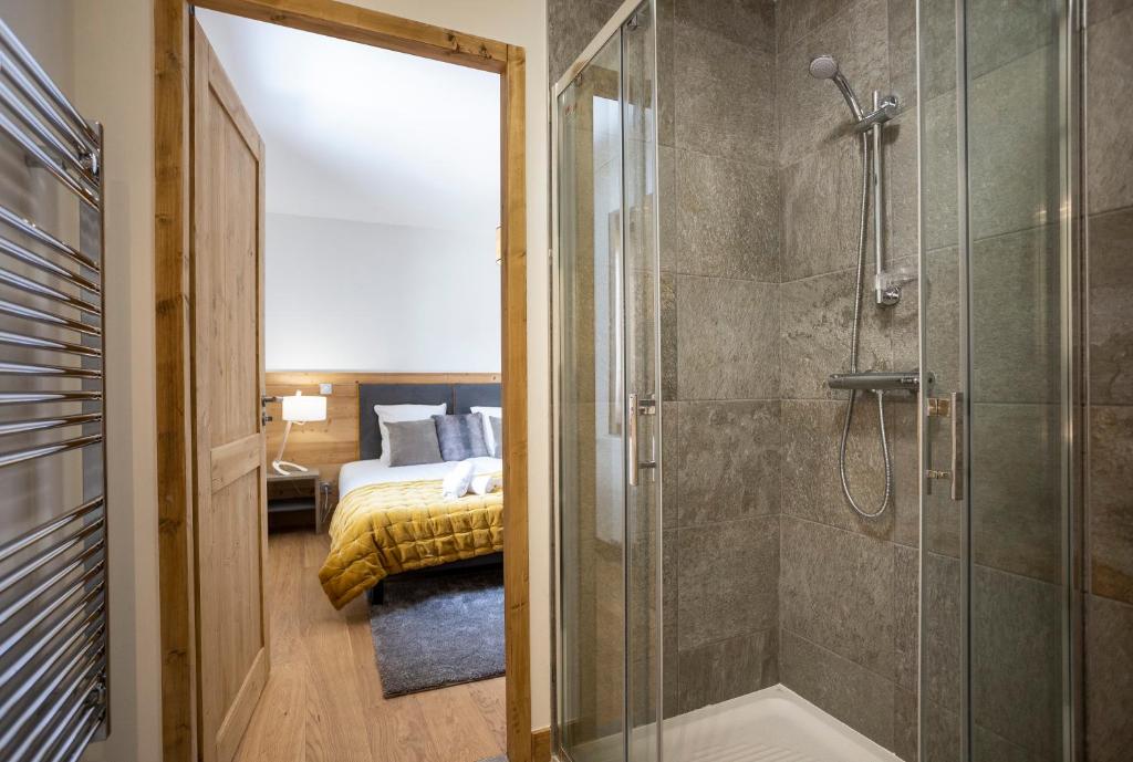 une salle de bain avec douche et une chambre avec un lit dans l'établissement TERRESENS - Le Diamant des Neiges, à Plagne 1800