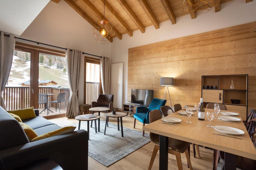 un salon avec une table et des chaises dans l'établissement TERRESENS - Le Diamant des Neiges, à Plagne 1800