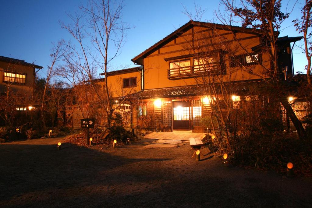 une maison avec des lumières devant elle la nuit dans l'établissement Ryokan Kono-Yu, à Minamioguni
