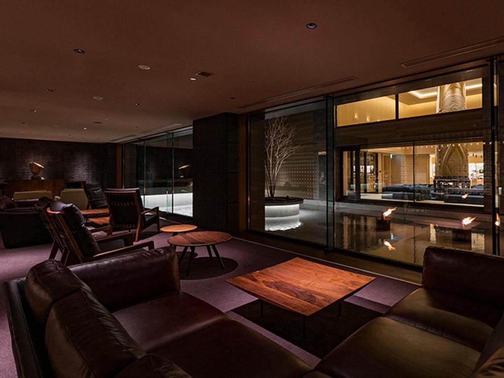 Elle comprend un salon doté d'un mobilier en cuir et d'une grande fenêtre. dans l'établissement Lake Shikotsu Tsuruga Bessou AO no ZA, à Chitose