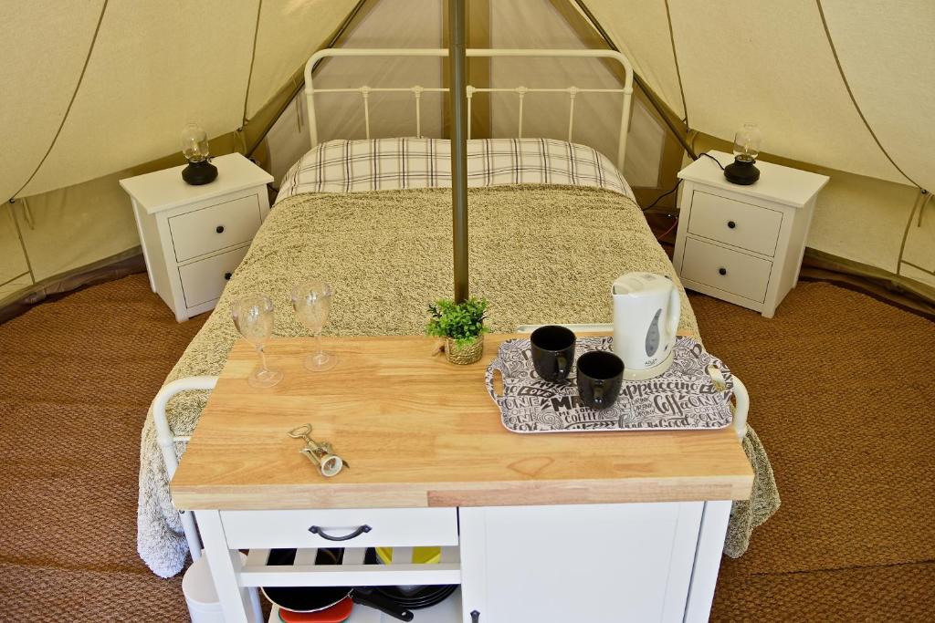 une chambre avec un lit et une table dans une tente dans l'établissement Glamping at Camping La Source, à Saint-Pierre-dʼArgençon
