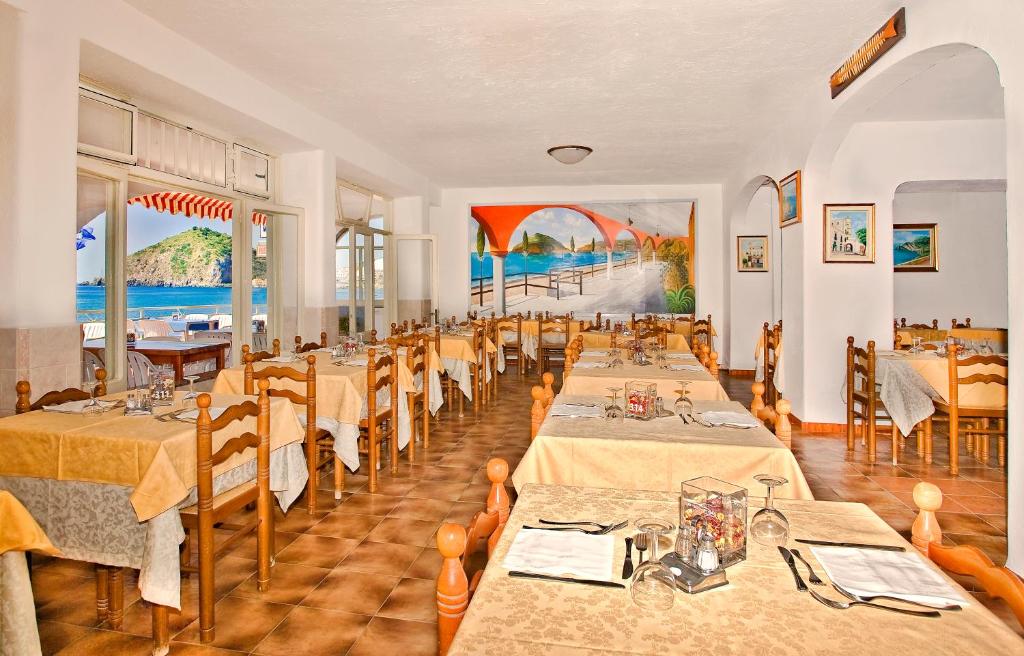 un restaurant avec des tables et des chaises dans une salle dans l'établissement Hotel Vittorio Beach Resort, à Ischia 40 autres photos