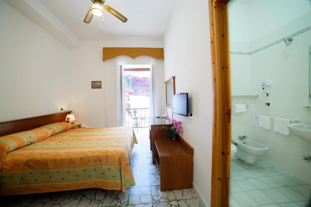 une chambre avec un lit, une baignoire et un lavabo dans l'établissement Hotel La Mandorla, à Ischia