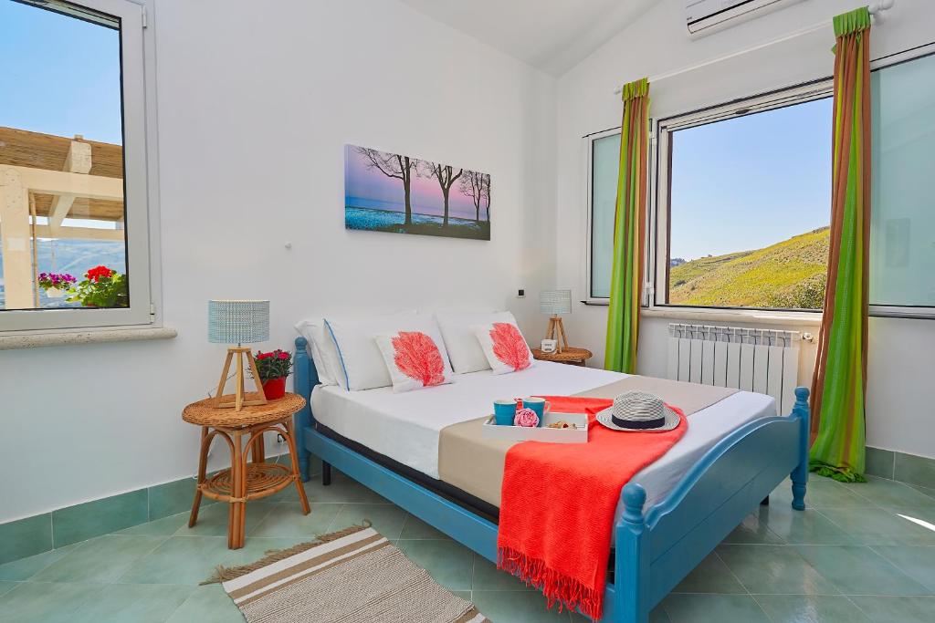 une chambre avec un lit et deux fenêtres dans l'établissement Villa Sirena - Scopello-Villas, à Scopello