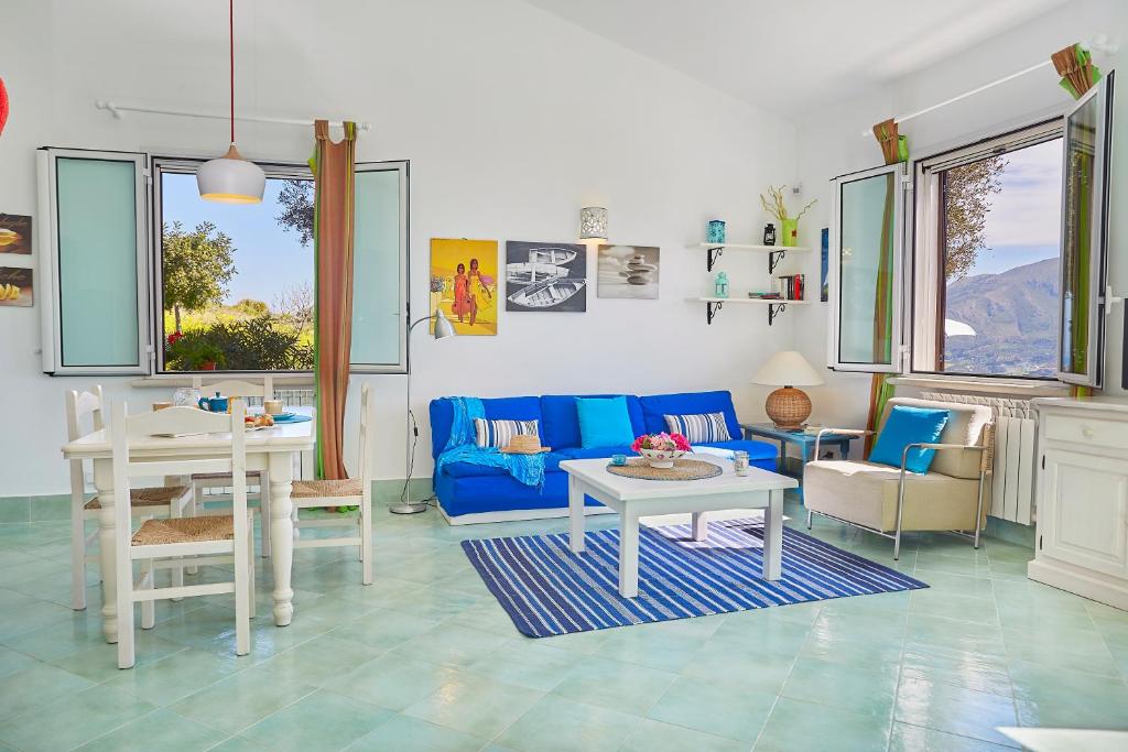 un salon avec un canapé bleu et une table dans l'établissement Villa Sirena - Scopello-Villas, à Scopello
