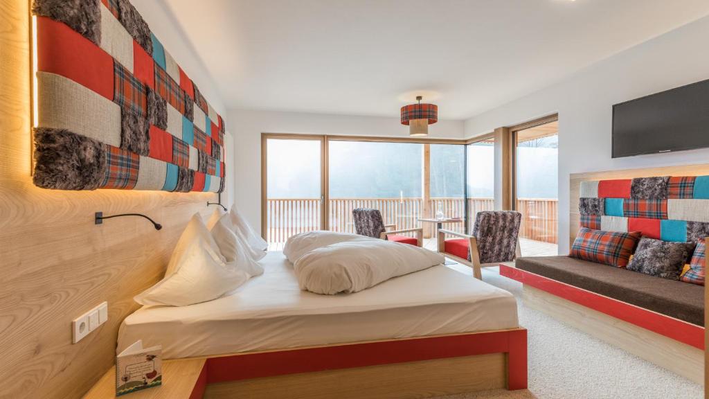 une chambre d'hôtel avec un lit et un balcon dans l'établissement Hotel Weihrerhof, à Soprabolzano