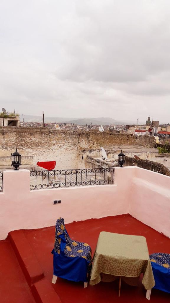 d'une terrasse avec deux chaises et une table offrant une vue. dans l'établissement Dar nadaa, à Fès 14 autres photos