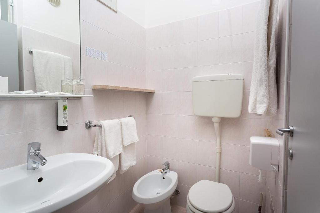 une salle de bain blanche avec un lavabo et des toilettes dans l'établissement Hotel Caribe - Garda Lake Collection, à Brenzone