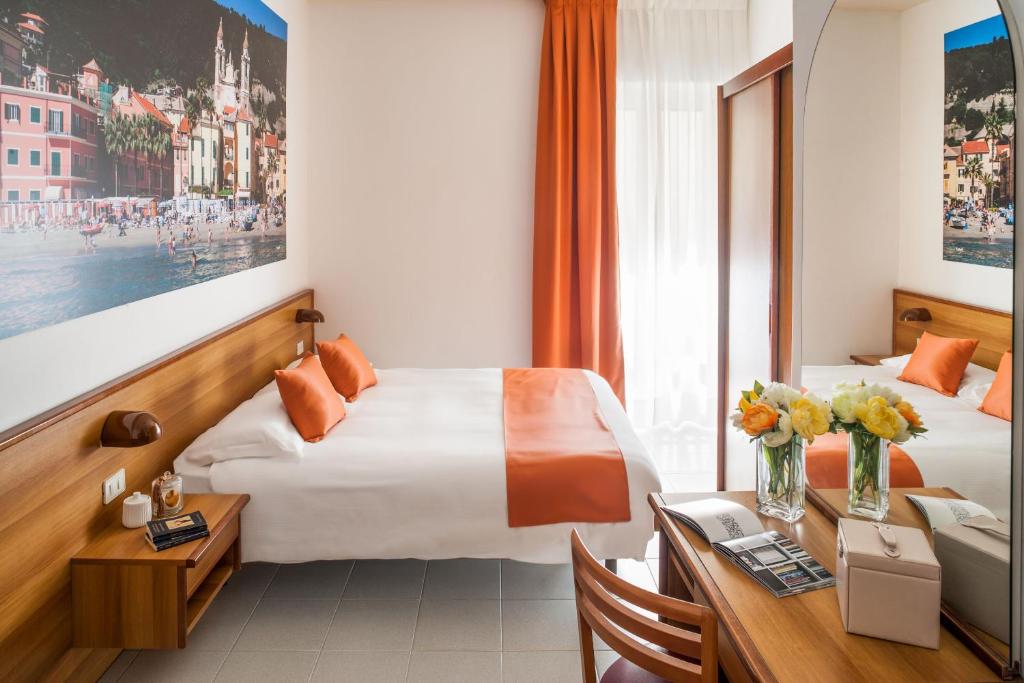 une chambre d'hôtel avec deux lits et un bureau dans l'établissement Hotel Gilda, à Laigueglia 29 autres photos