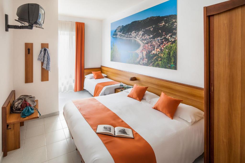 une chambre d'hôtel avec deux lits avec des chaussures dessus dans l'établissement Hotel Gilda, à Laigueglia