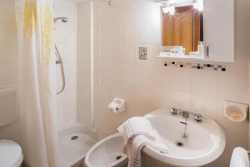 une salle de bain avec un lavabo, une douche et des toilettes dans l'établissement Hotel Gilda, à Laigueglia