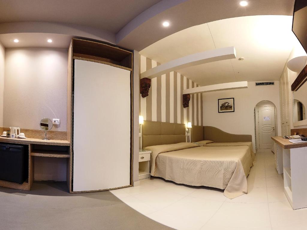 une chambre d'hôtel avec un lit et une salle de bain dans l'établissement Hotel Derby Exclusive, à Milano Marittima